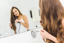 Woman using HerStyler flat iron to style hair
