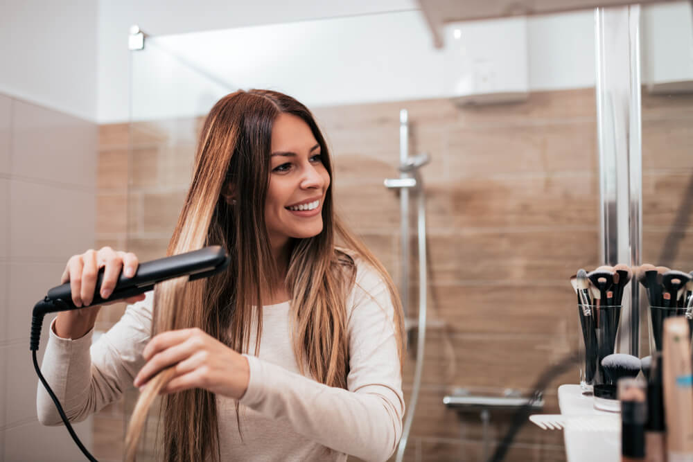 Woman straightening hair