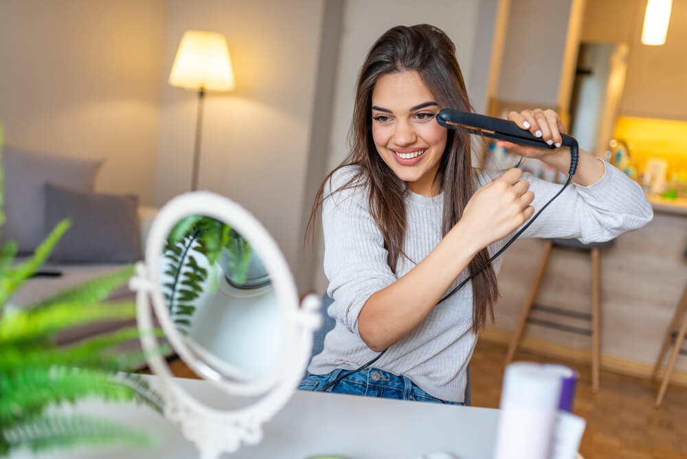 Woman straightening hair