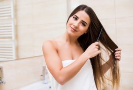 Woman combing hair in bathroom